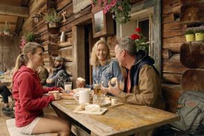 Freunde bei der Brotzeit auf der Almhütte